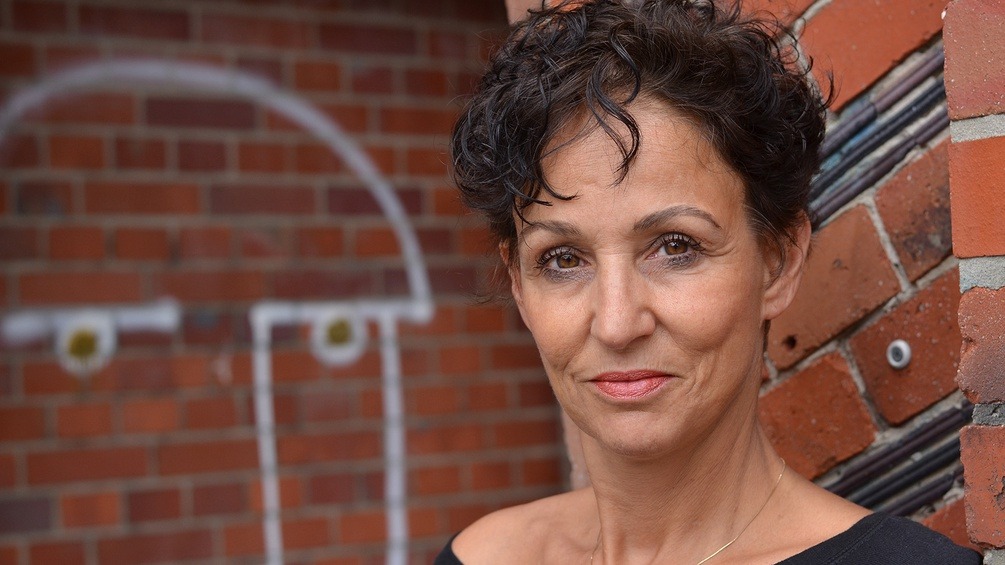 Sandra Kreisler vor einer Backsteinmauer