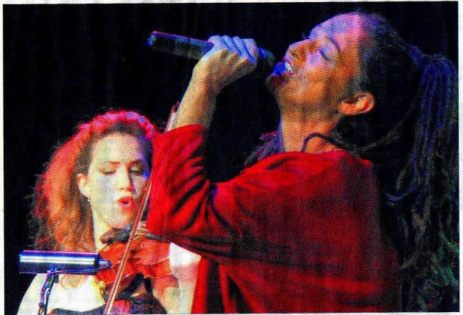 Sandra Kreisler singt mit erhobenem Mikrofon, dahinter Kinneret Sieradzky an der Geige